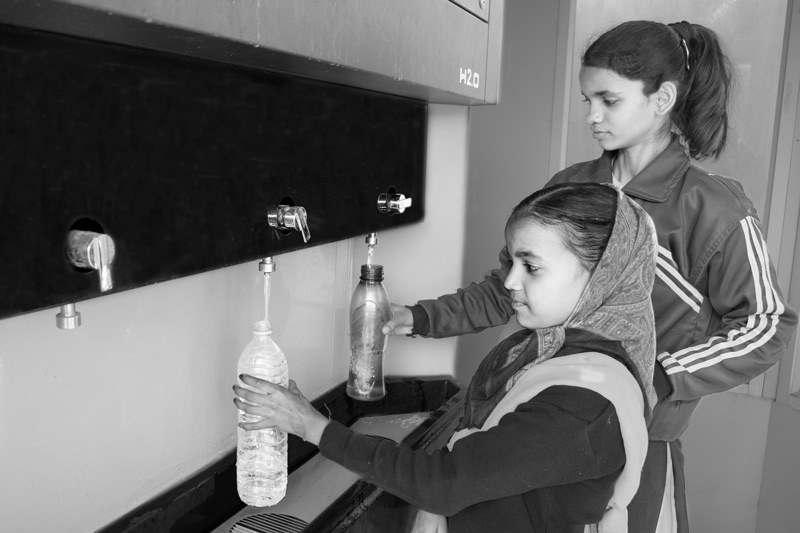 Leaving No One Behind: Human Right to Water in India - Students procuring safe drinking water free of cost from a 'Water ATM' within school premises in an arsenic-affected village in Bhojpur district, Bihar